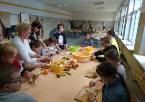 Wychowankowie internatu przygotowują sałatkę owocową.