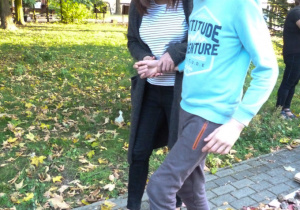 Michał spaceruje po jesiennej ścieżce sensorycznej.