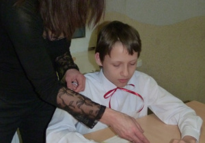 Michał z pomocą p. Uli wykonuje kotylion