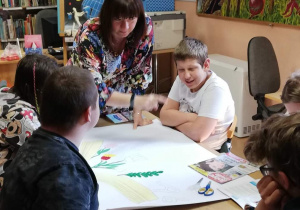 Pani Małgosia pomaga dzieciom przy pracy