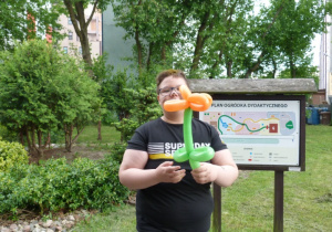 Dominik z pomarańczowym kwiatem z balonów