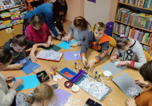 Dzieci wykonują prace plastyczne o bałwankach