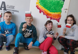 Dzieci prezentują wykonaną mapę Polski i biało-czerwone flagi