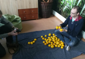 Warsztaty fotograficzne Rehabilitacja 25 plus Marcin podczas sesji z cytrynami.
